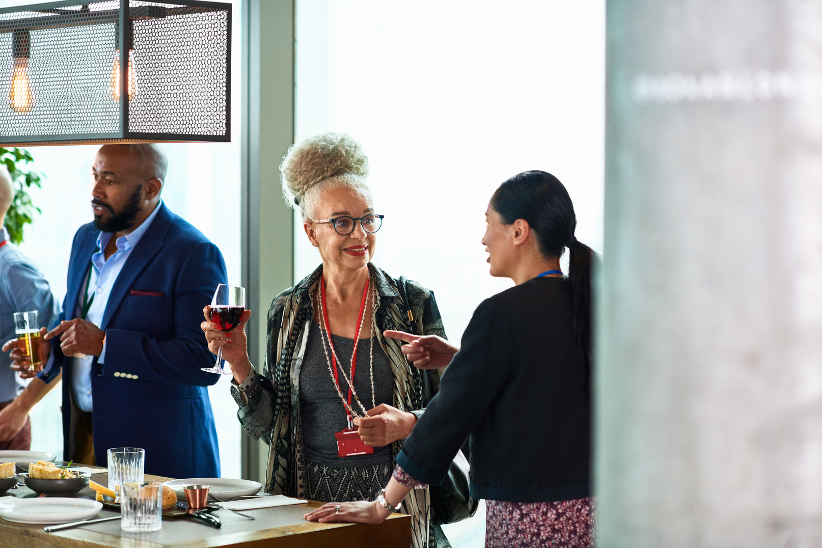 Senior woman drinking wine at business networking event